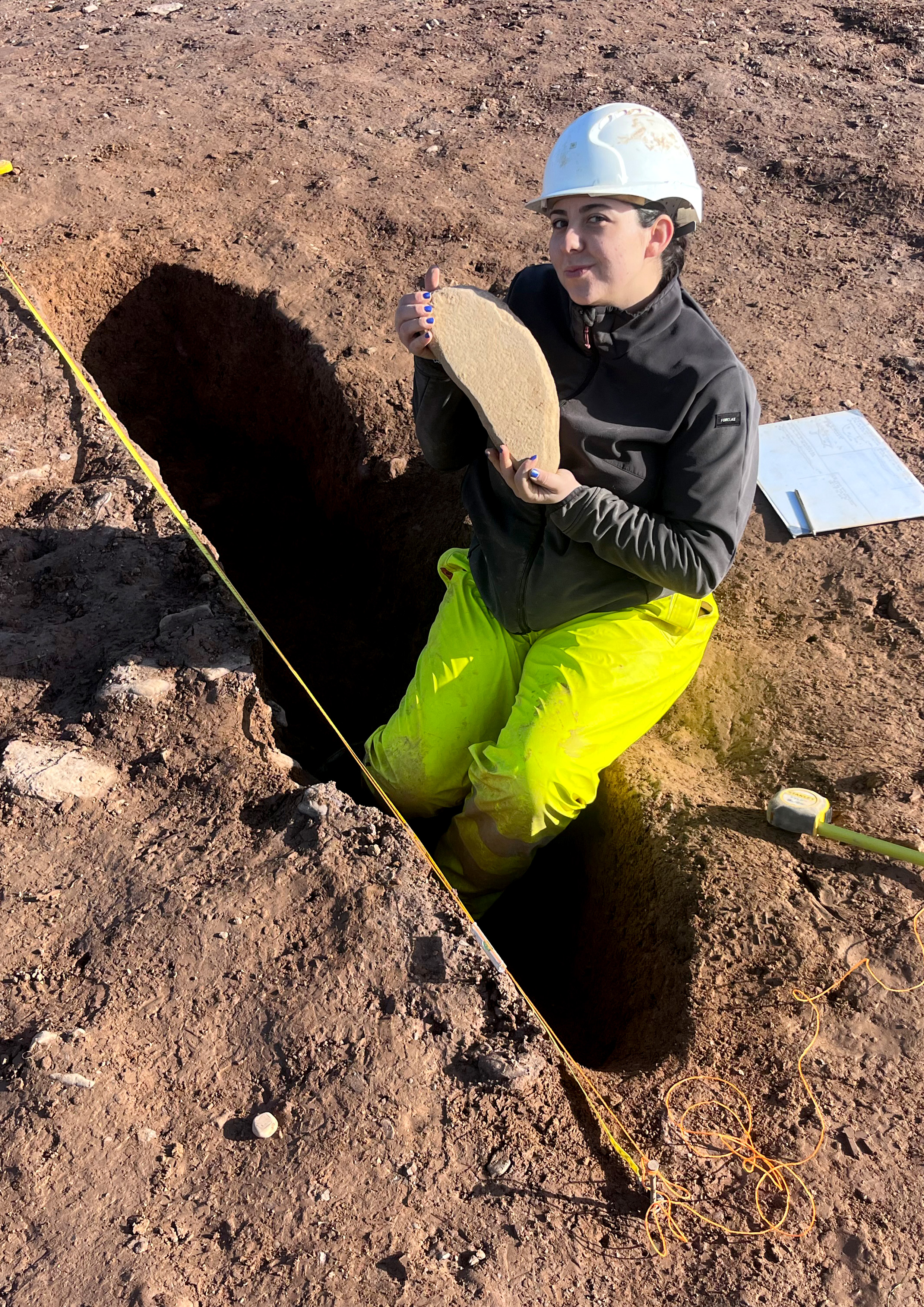 Rubicon archaeologist Paula Jardi Talavera holding a quernstone fragment